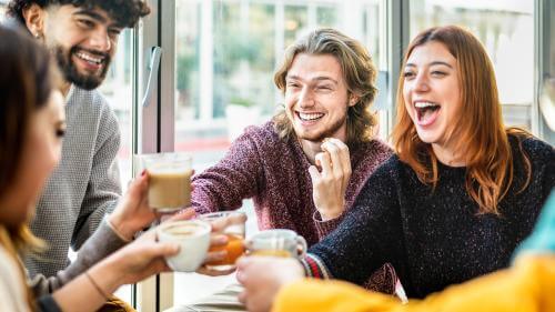 A group of people smiling and laughing in a cafe