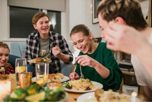 A group of students laughing and eating