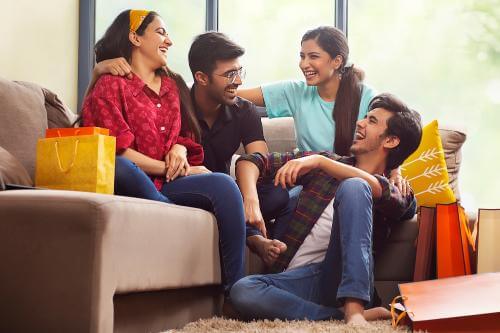 A group of students laughing on a sofa